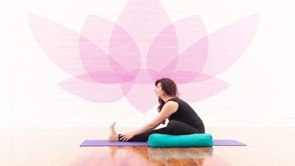 Seated Forward Fold yoga pose to stretch hamstrings and lower back for padel recovery.