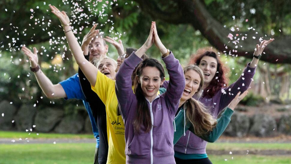 People practising outdoor yoga in Cork with a teacher leading the class