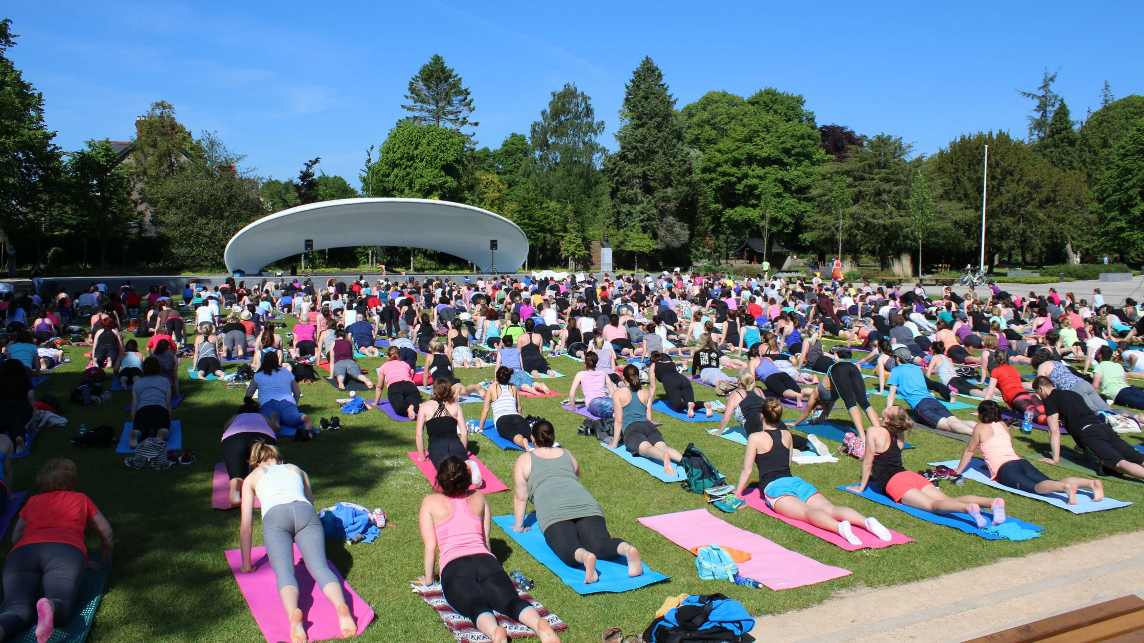 Community yoga in the park in Cork City with mats rolled out on the grass